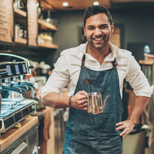 Man standing next to coffee machine.